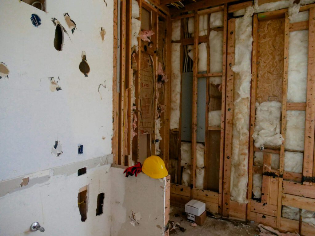 Gutted interior room with exposed studs and insulation during a restoration project in Lancaster.